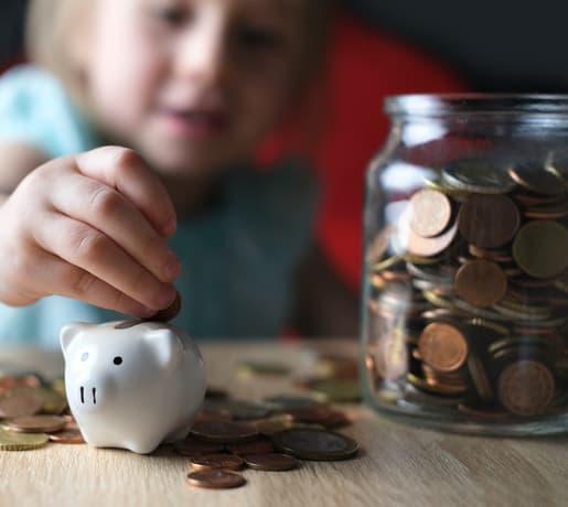 petite fille remplissant sa tirelire